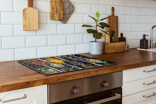Inductiebeschermer met kruiden in een keuken met veel wit en hout