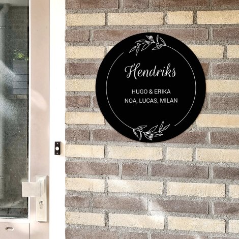 Rond naambordje voordeur botanisch op een lichte muur