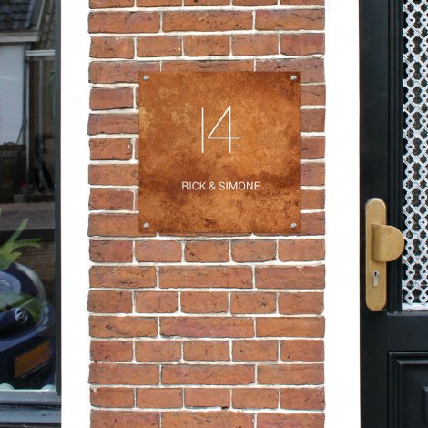 Vierkant naambordje voordeur roest aan de muur